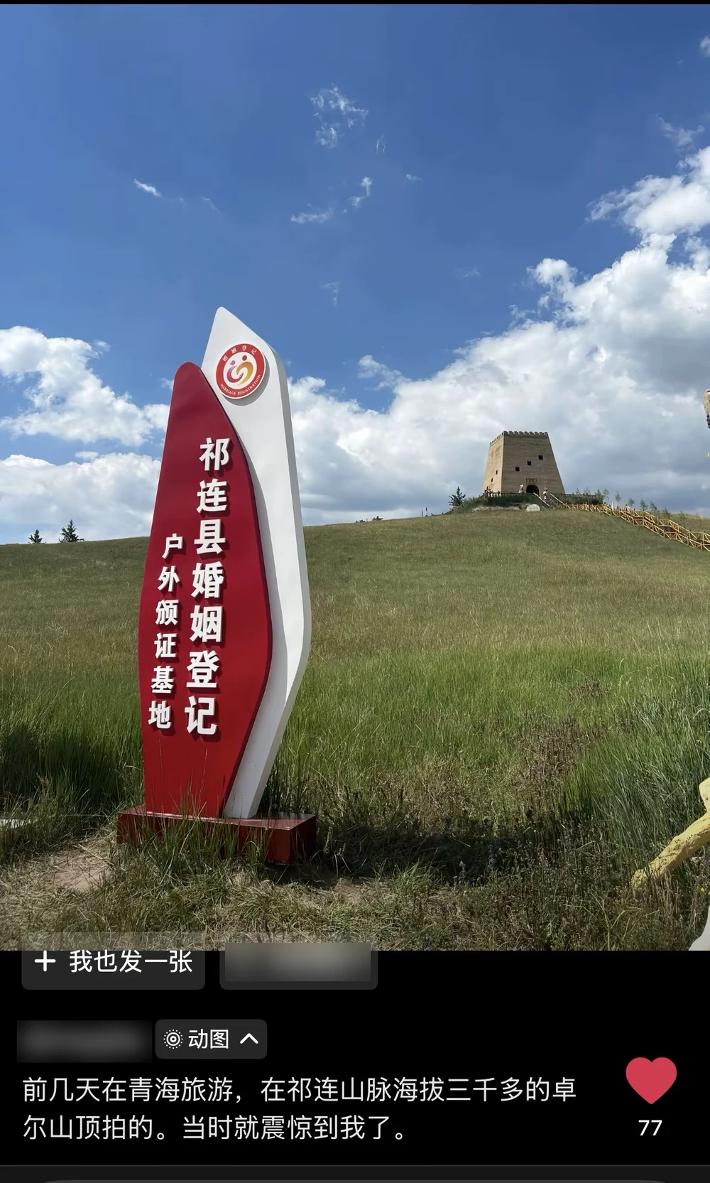 A photo of the Qilian County outdoor marriage-certificate base: a tall red sign on an alpine meadow at 3,000 meters, a watchtower on the ridge behind